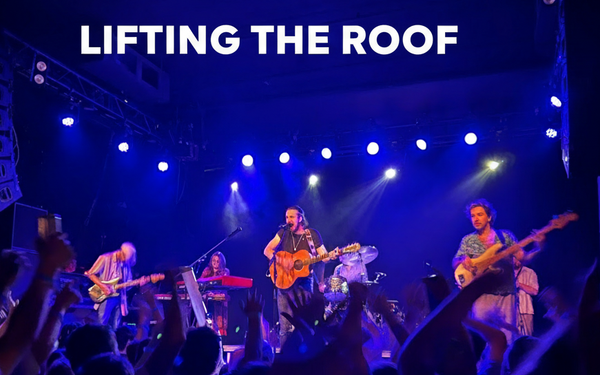 A rock band playing to an excited crowd. headline: Lifting the Roof in letters at the top